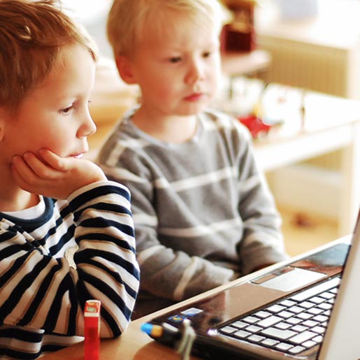 Zwei Kinder spielen am Laptop.